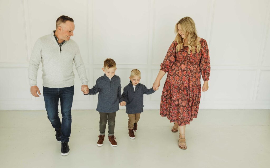 Mom and Dad holding their sons hands at a Plano,TX photography studio fall family session