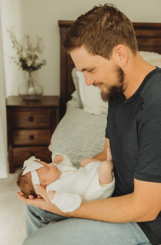 Father holding his baby girl during their in-home newborn photography session